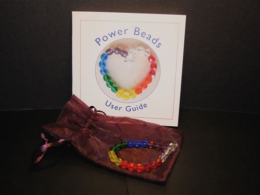 power-bead bracelet sitting atop a sheer mesh bag in front of the user guide booklet
